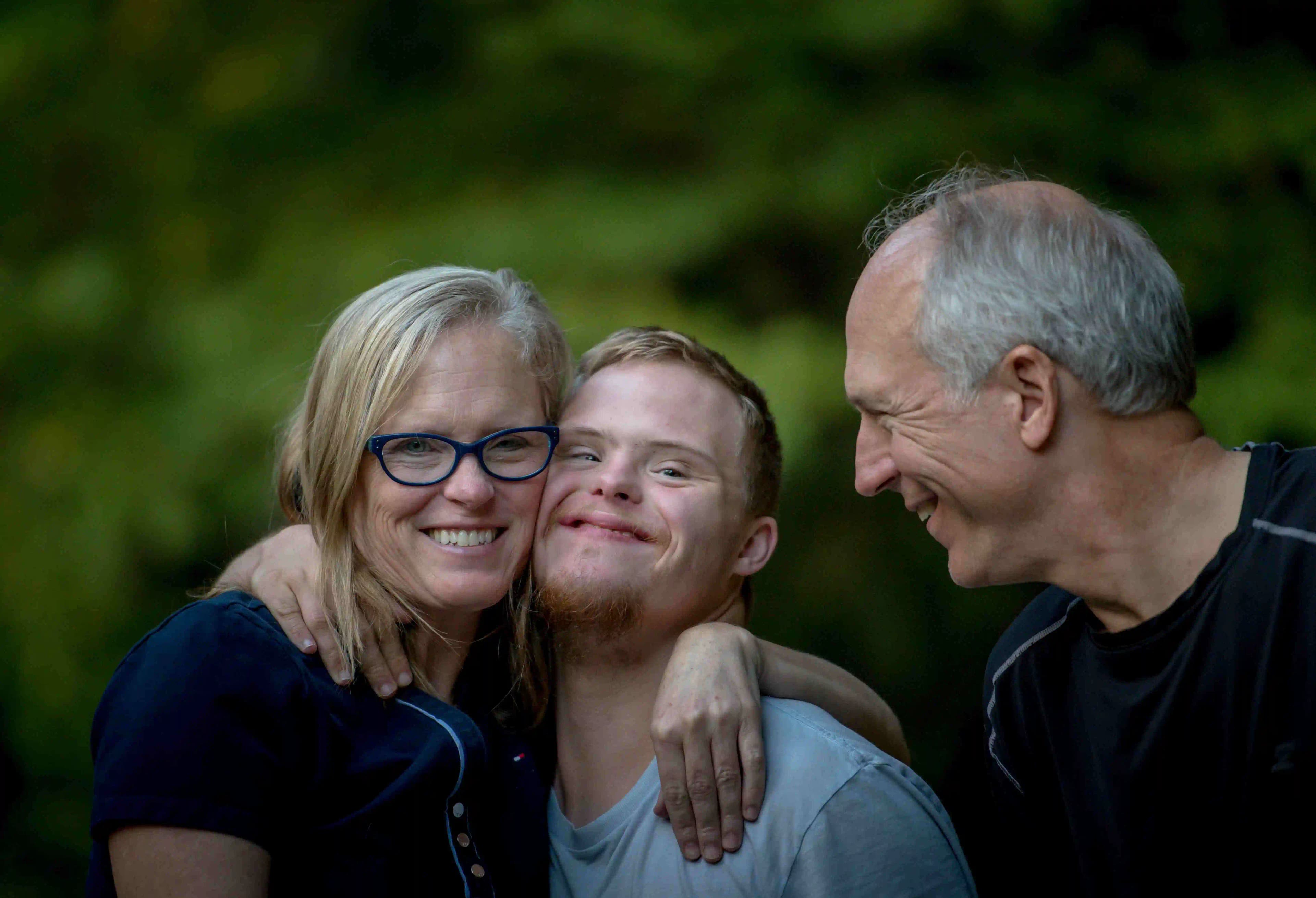 A group of people with disabilities smiling and looking at the camera.