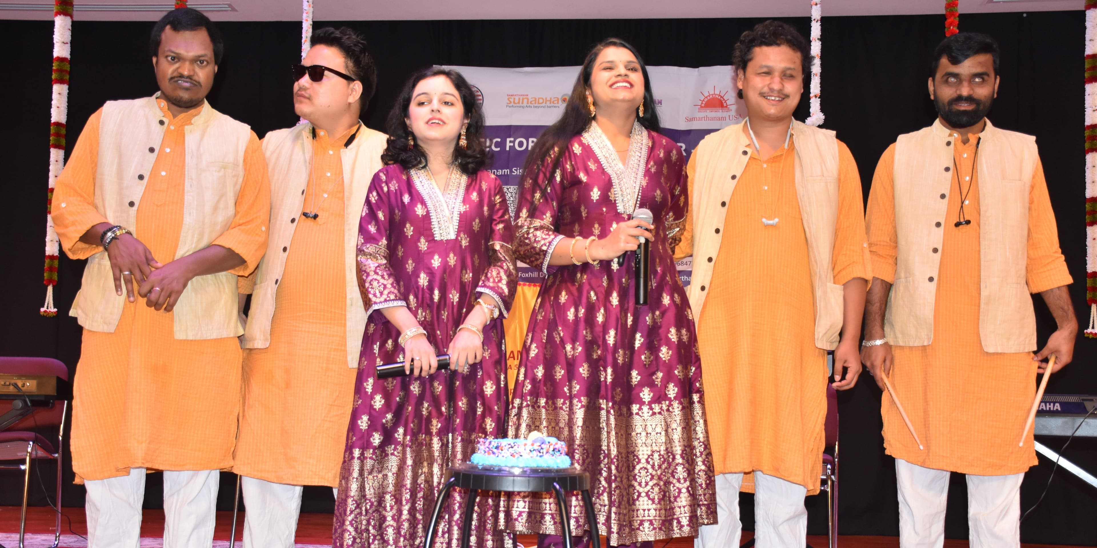 A group of people with disabilities smiling and looking at the camera.