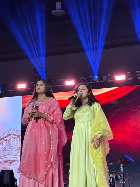 Both singers on the stage, Vasundhara is singing